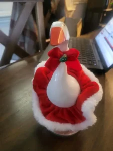 A tabletop goose dressed in a festive red Christmas costume