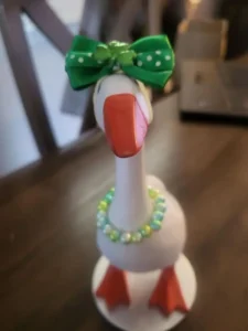 A tabletop goose in a green polka dot dress with a matching bow